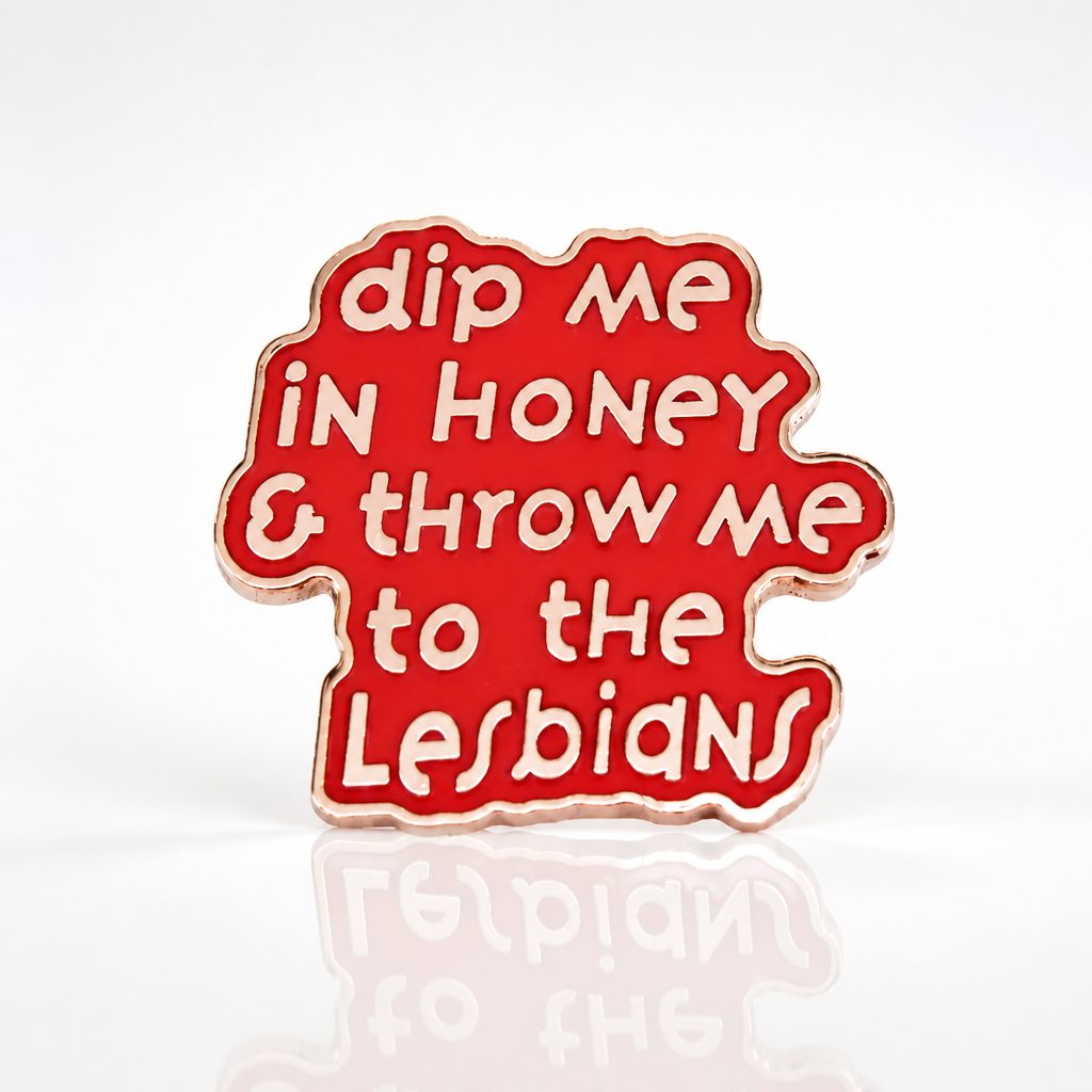 Pink enamel pin with the phrase “Dip Me in Honey & Throw Me to the Lesbians”