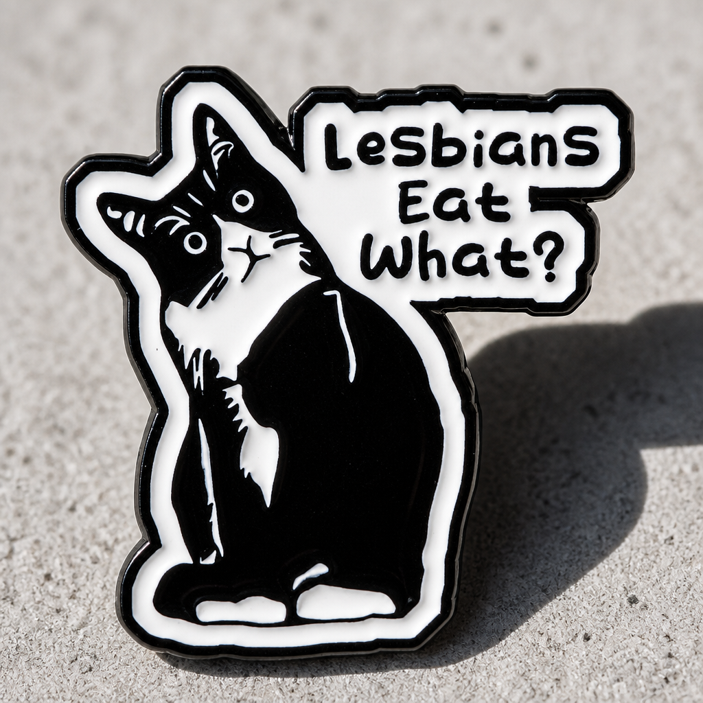 Funny tuxedo cat enamel pin with the phrase “Lesbians Eat What?” on a concrete surface
