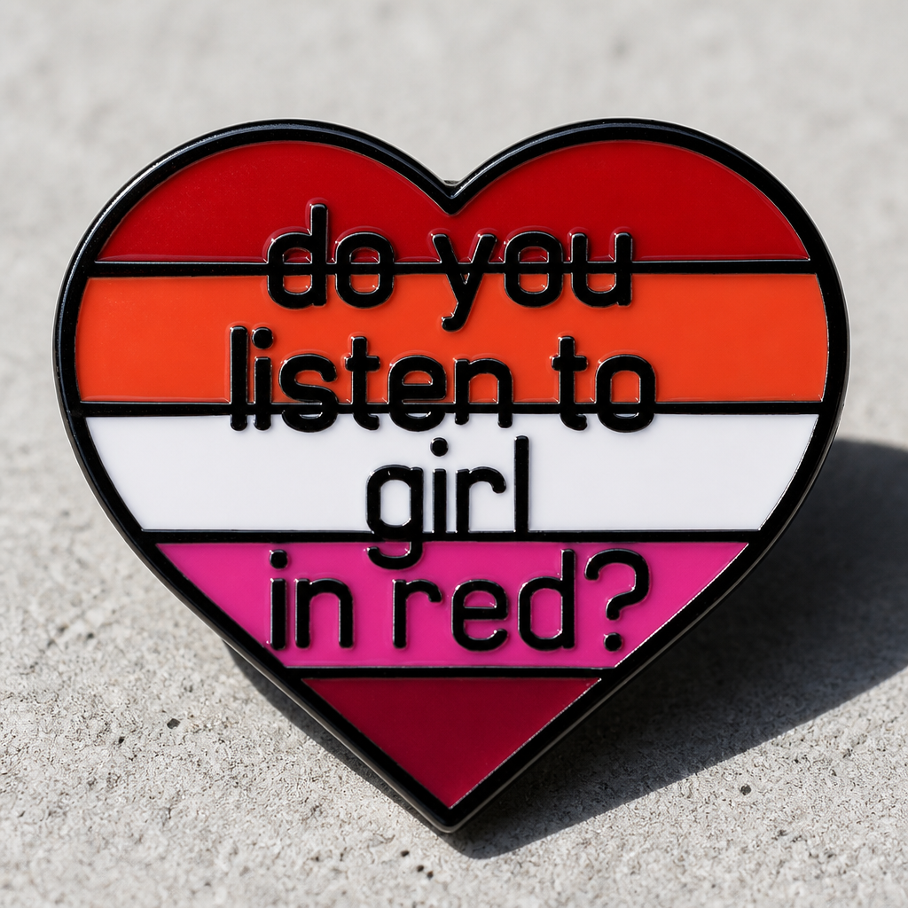 Heart-shaped lesbian Pride enamel pin reading “Do You Listen to Girl in Red?” on a concrete surface