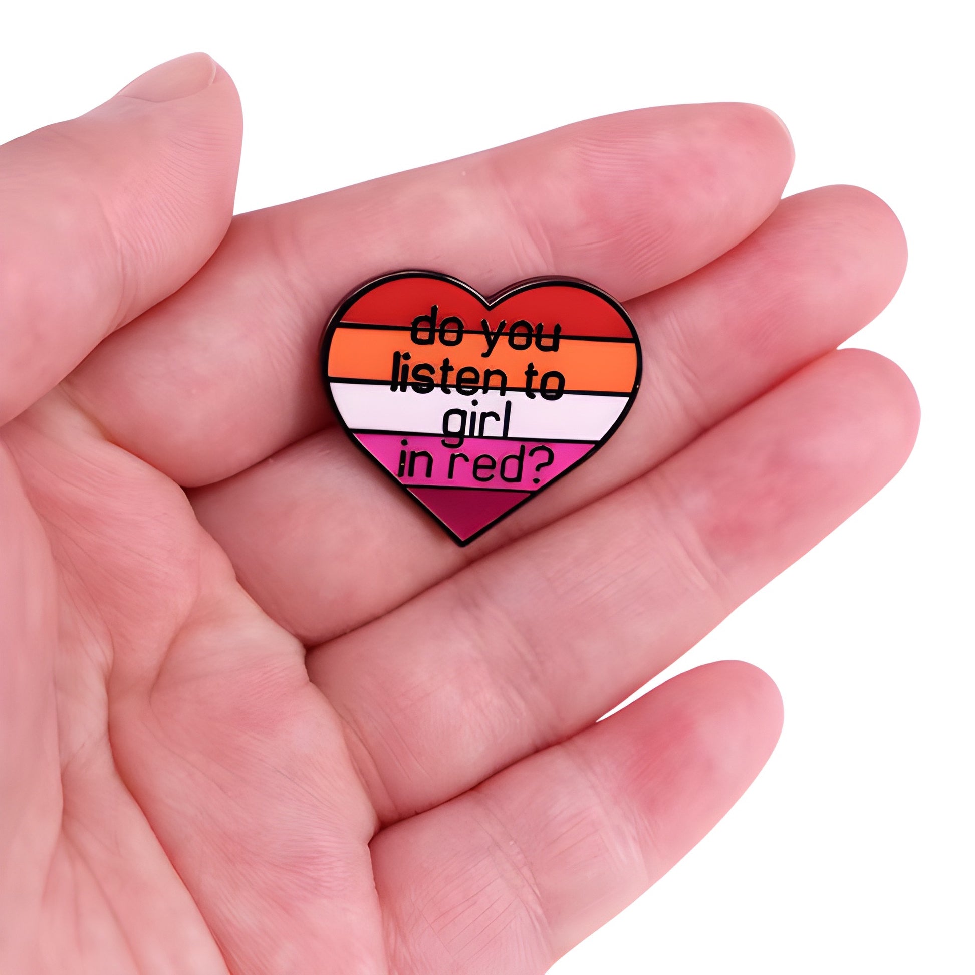 Heart-shaped lesbian Pride enamel pin reading “Do You Listen to Girl in Red?” held in a hand