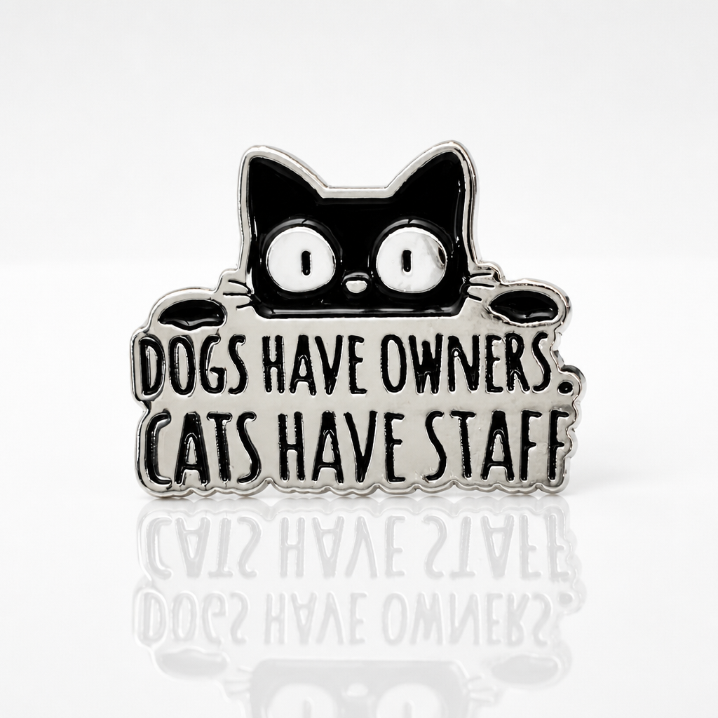Funny enamel pin featuring a black cat and the phrase Dogs Have Owners Cats Have Staff
