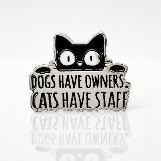 Funny enamel pin featuring a black cat and the phrase Dogs Have Owners Cats Have Staff