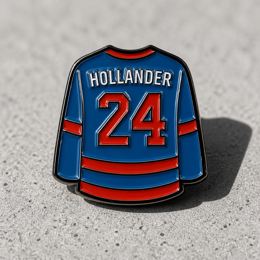 Heated Rivalry Hollander home jersey enamel pin with blue and red hockey uniform design on a concrete surface