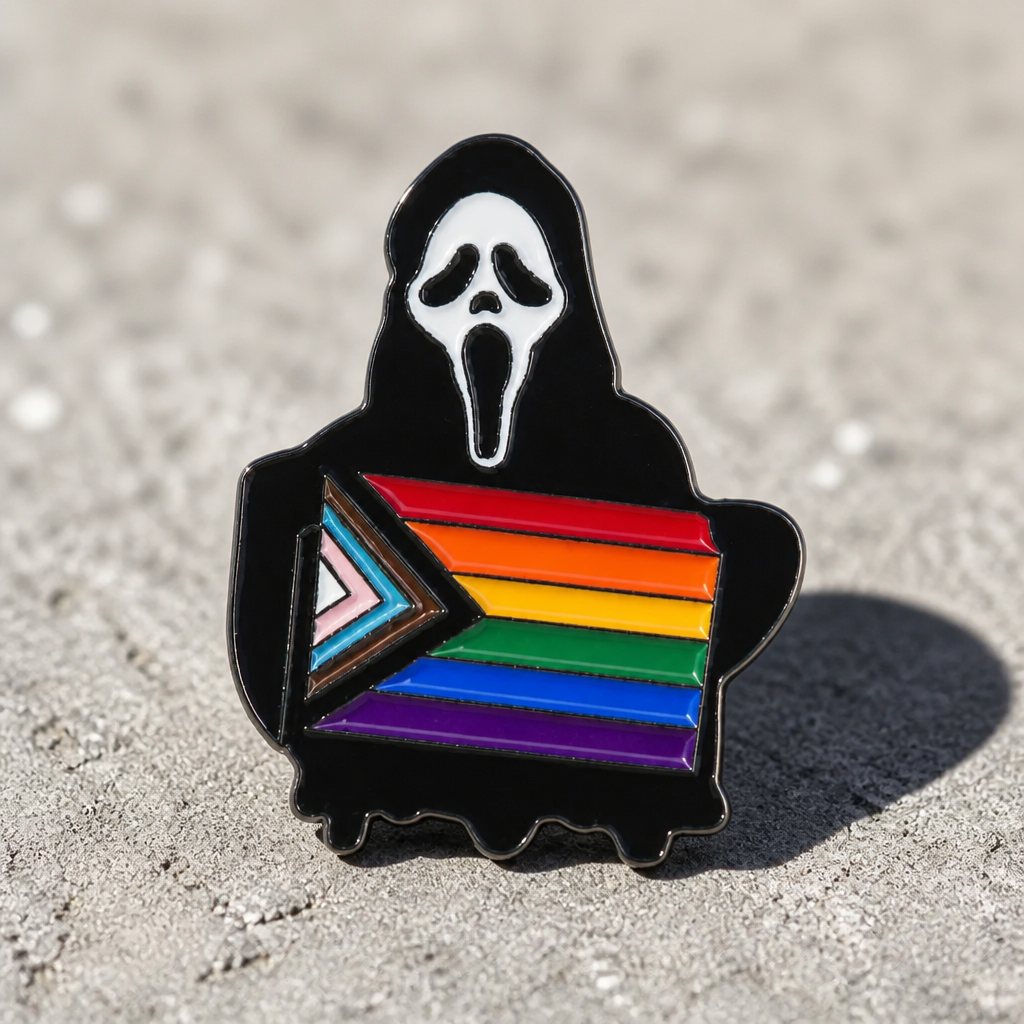 Ghostface-inspired enamel pin featuring a black robed horror character holding the Progress Pride flag on a concrete surface
