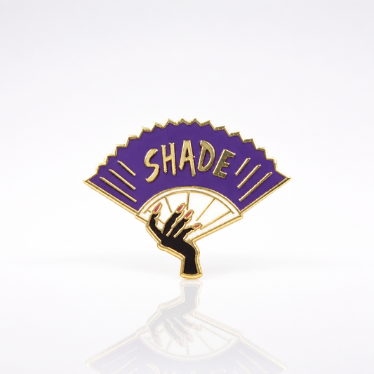 Purple Shade enamel pin featuring a dramatic folding fan design with gold-tone details