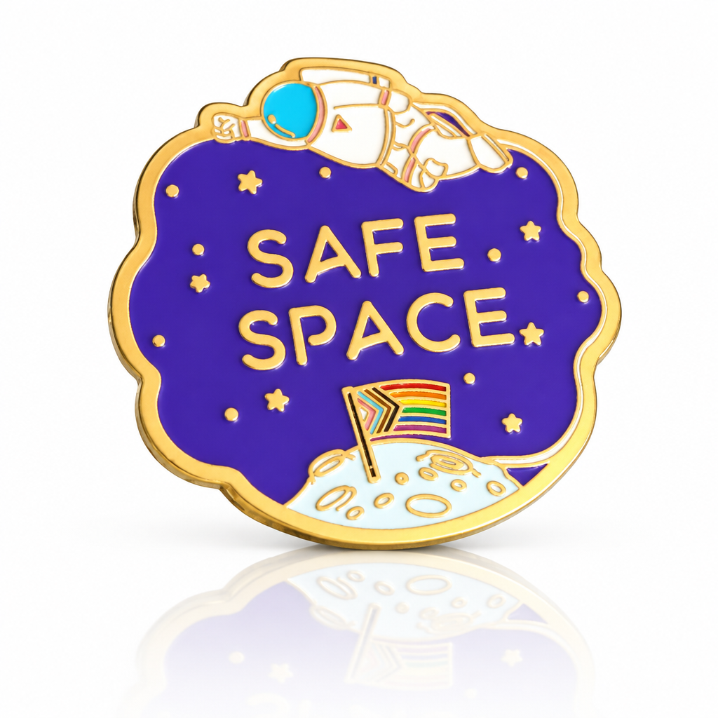Gold hard enamel Safe Space pin with astronaut, stars and a Progress Pride flag planted on the moon.
