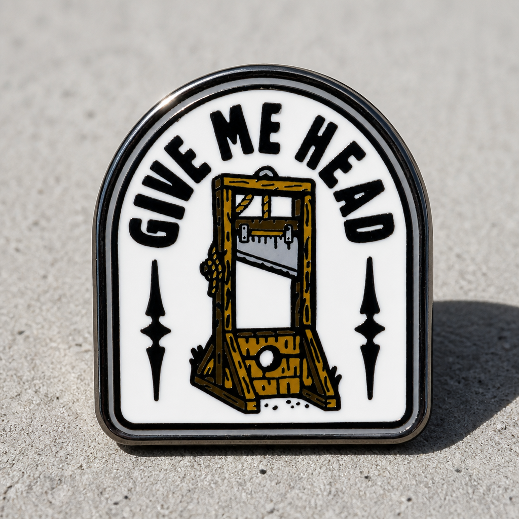 Give Me Head enamel pin featuring a vintage guillotine illustration and humorous text on a concrete surface