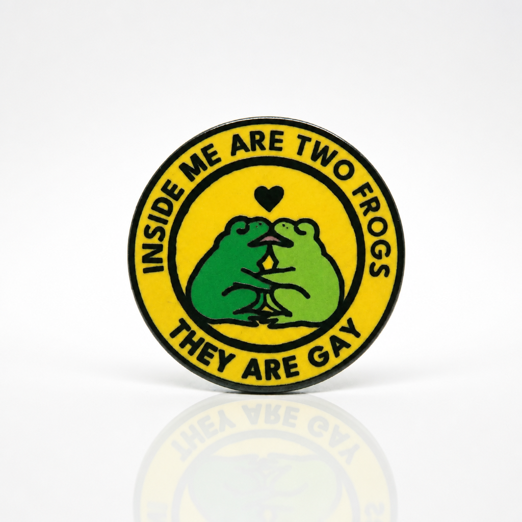 Hard enamel pin featuring two green frogs kissing with the phrase Inside Me Are Two Frogs They Are Gay