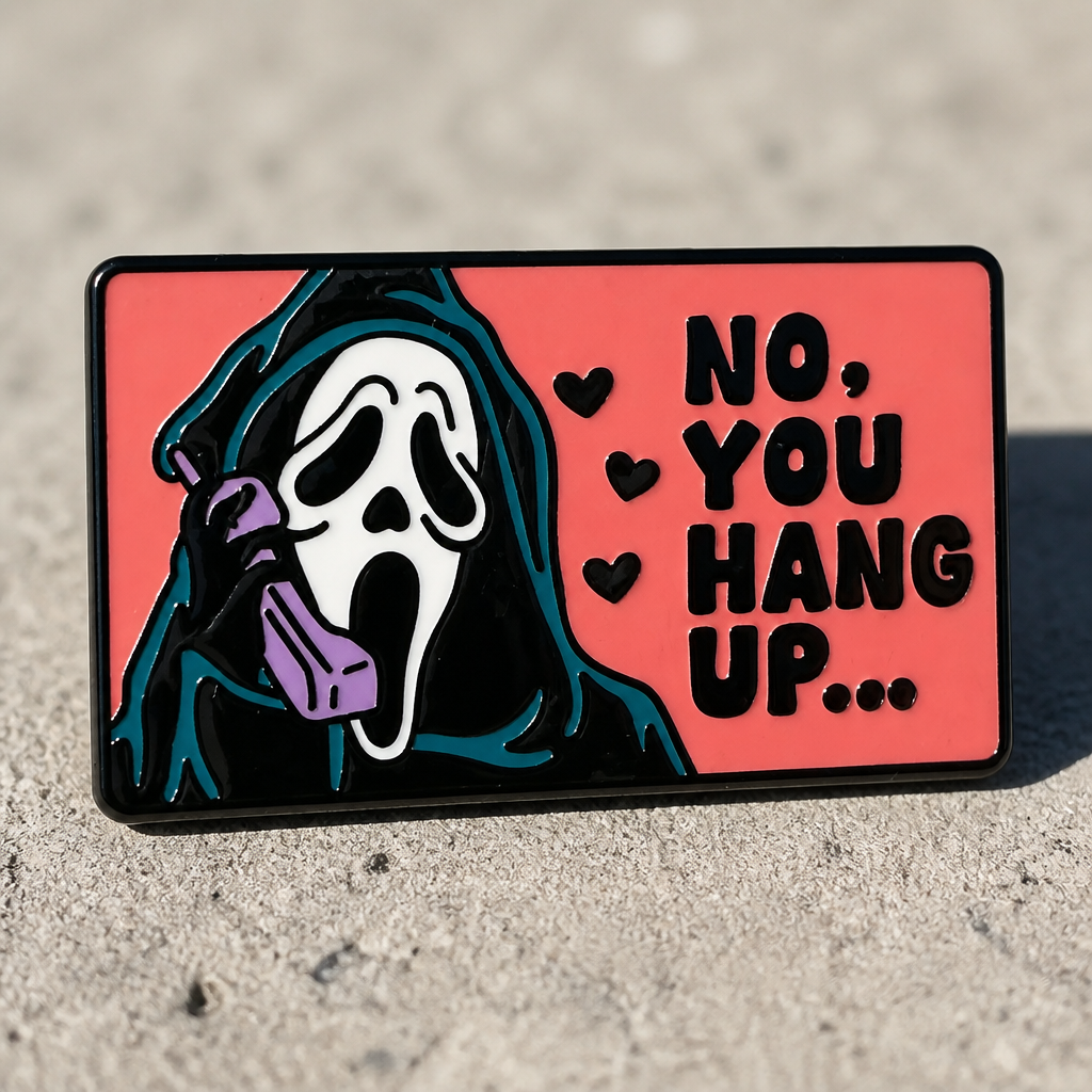 Hard enamel pin featuring a masked horror movie caller holding a pink telephone with the phrase No You Hang Up on a cement background