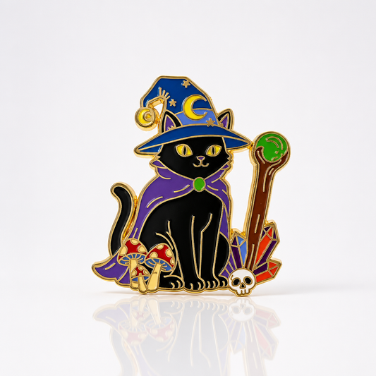 Premium gold hard enamel pin featuring a magical black cat wearing a wizard hat, holding a crystal staff, surrounded by mushrooms, colorful crystals, and a tiny skull.