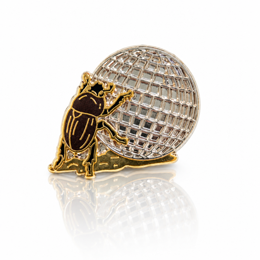 Disco Beetle enamel pin featuring a brown beetle rolling a large silver disco ball