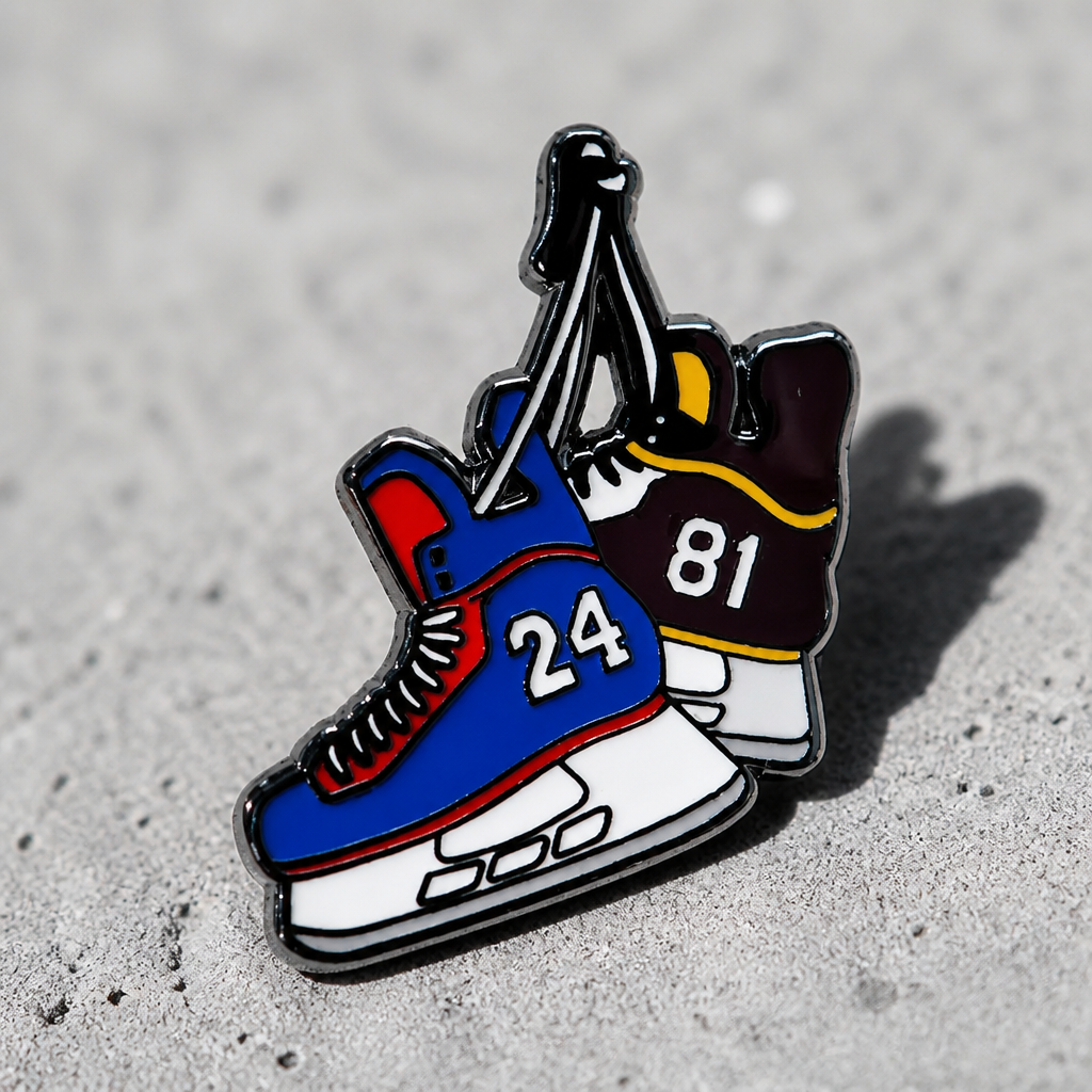 Hard enamel Heated Rivalry hockey skates pin featuring blue and black skates with jersey numbers 24 and 81 hanging together on a concrete surface