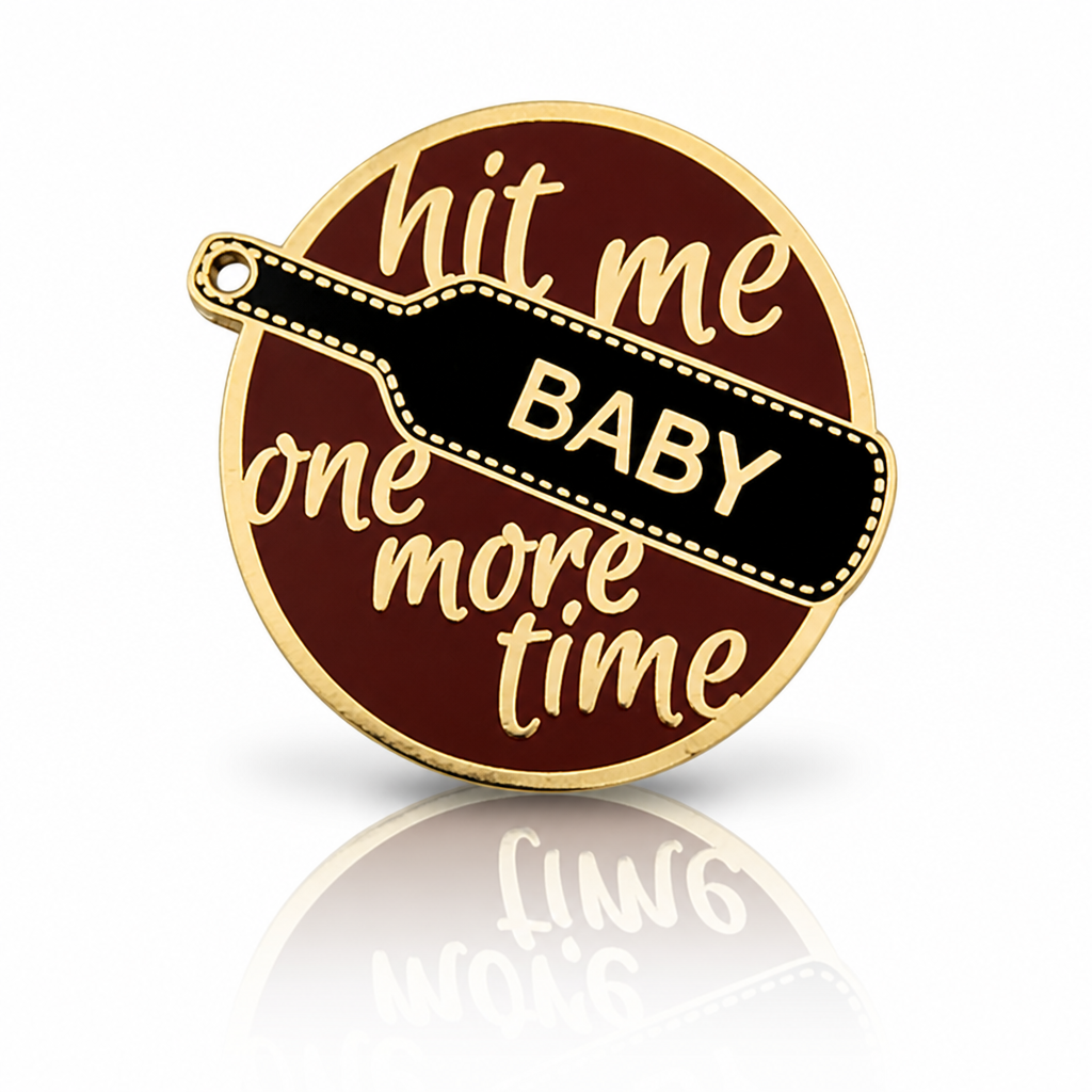 Hit Me Baby One More Time enamel pin with black paddle and gold-tone metal