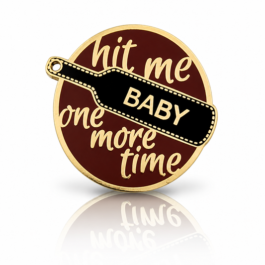 Hit Me Baby One More Time enamel pin with black paddle and gold-tone metal