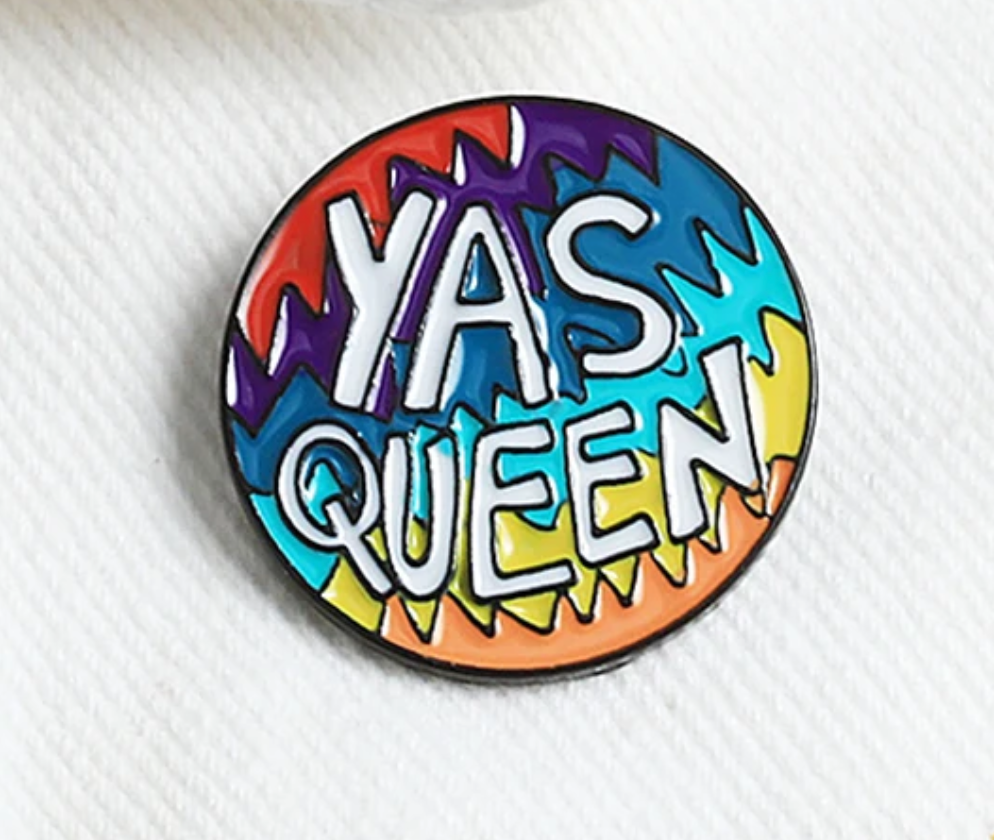 Yas Queen Rainbow enamel pin with colorful Pride-inspired lettering design on a white background