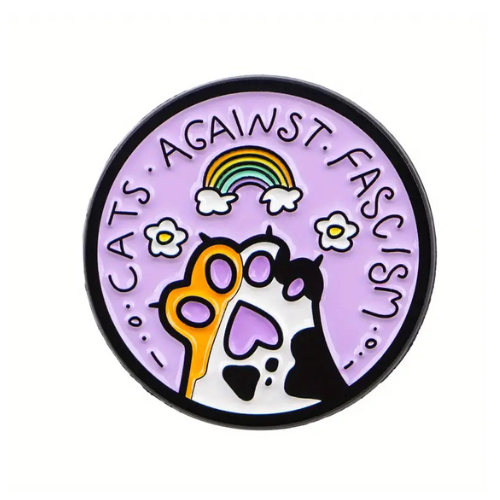 Pastel enamel pin reading “Cats Against Fascism” with rainbow and cat paw artwork