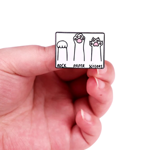 Hand holding a small rectangular card with 'Rock Paper Scissors' illustration.