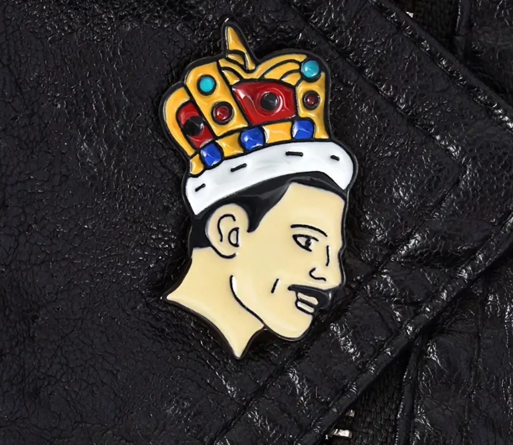 Legendary Freddie enamel pin featuring crowned glam rock inspired portrait artwork on a textured black surface