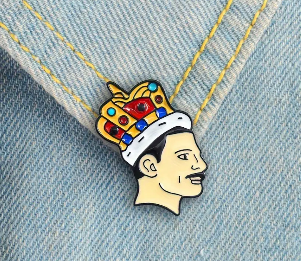 Legendary Freddie enamel pin featuring crowned glam rock inspired portrait artwork on a denim fabric