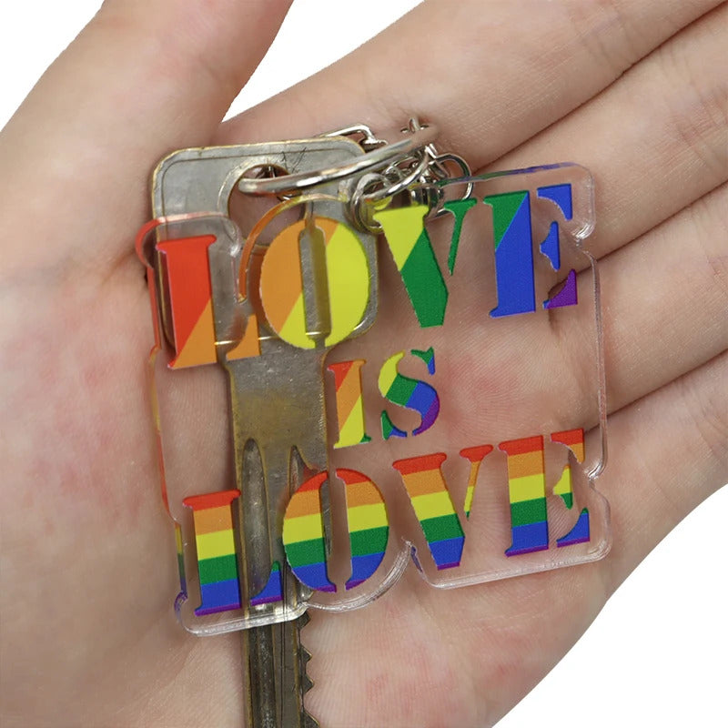 Love Is Love rainbow acrylic keychain with LGBTQ pride colors held in a hand
