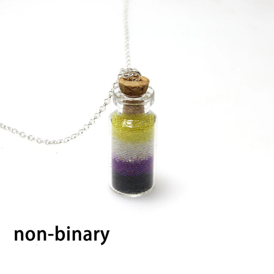 Nonbinary pride bottle necklace with layered yellow white purple and black micro-beads inside tiny glass bottle pendant
