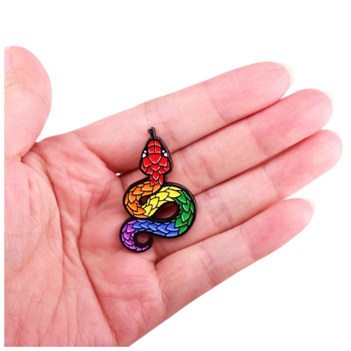 Rainbow Pride Snake enamel pin with colorful scaled serpent design held in a hand on a white background