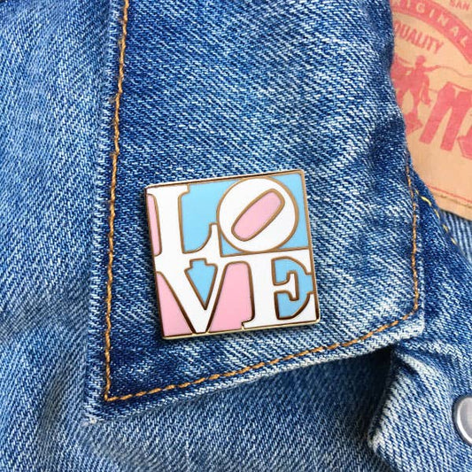 Heart-shaped transgender pride enamel pin with blue pink and white stripes and Love lettering