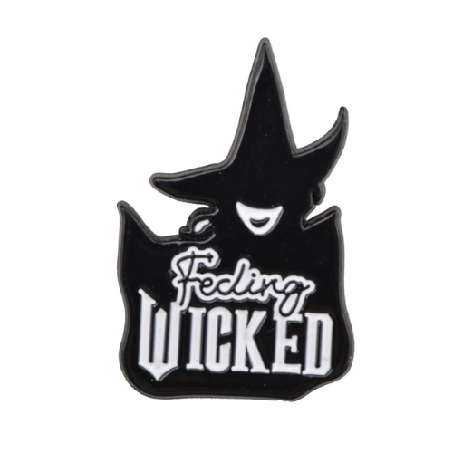 Feeling Wicked enamel pin featuring black witch silhouette and gothic lettering design